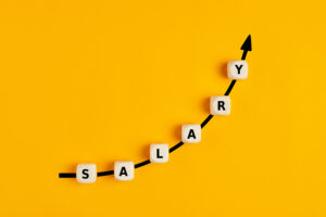 Salary raise or wage increase concepy with the word salary written on wooden blocks with an ascending arrow graph