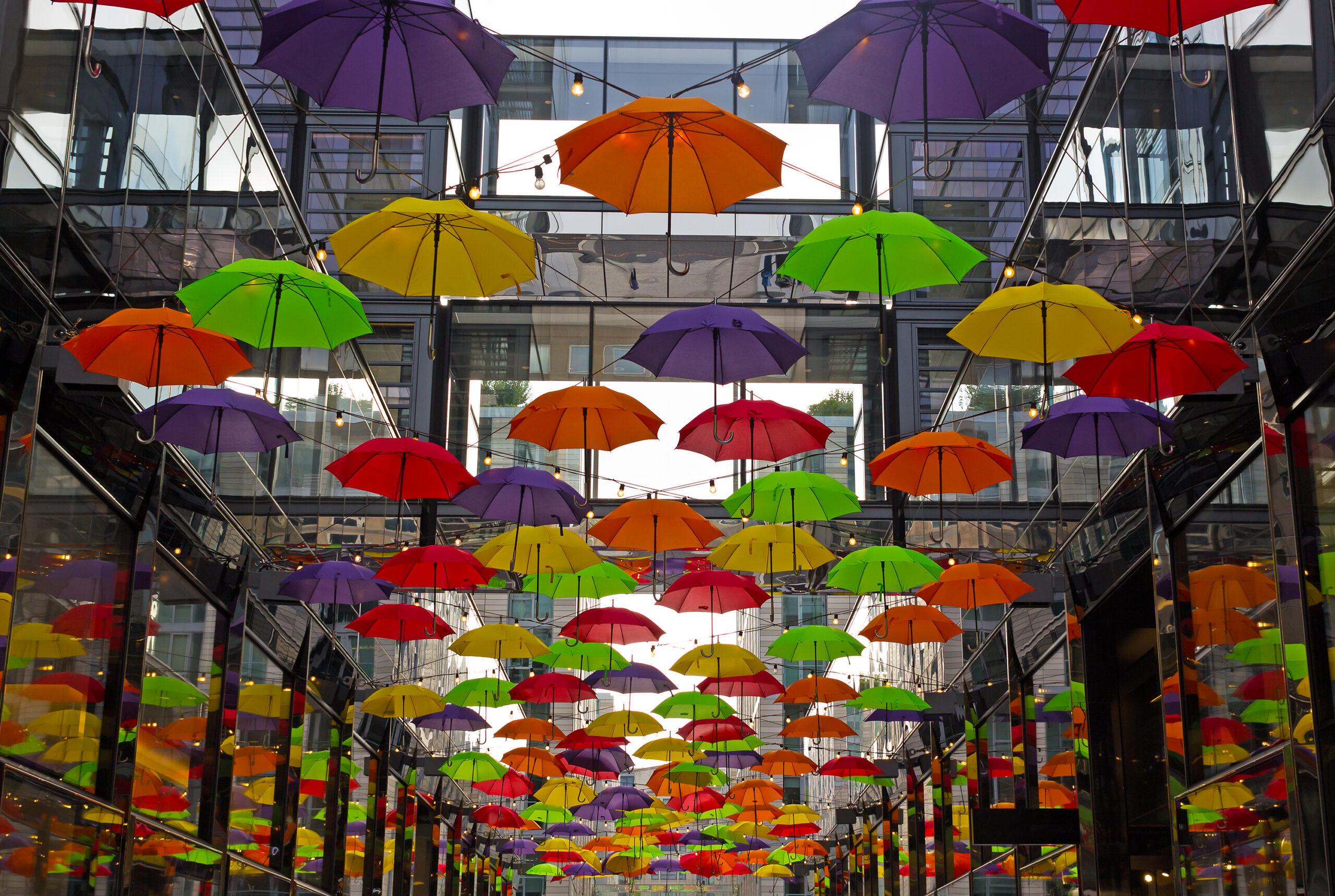 Colorful umbrellas on downtown street in Washington DC, USA. Umbrellas create a cozy friendly atmosphere on the street with shops and restaurants in US capital.